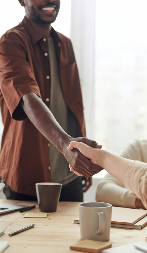 Two colleagues shaking hands in a business meeting, symbolizing cooperation and agreement.